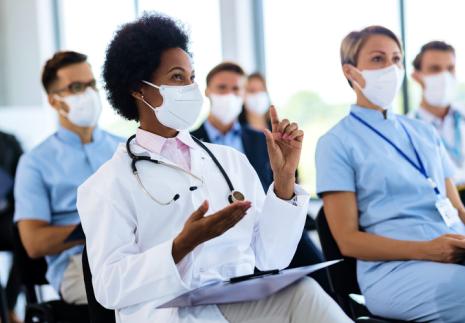 Healthcare workers in scrubs and PPE in a classroom setting